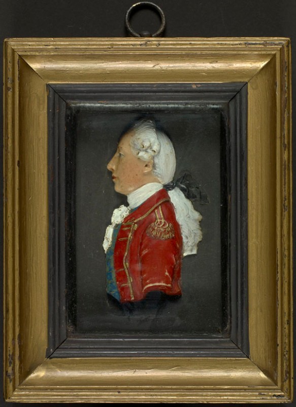 Portrait miniature en cire réalisé par un artiste anonyme au début du XIXe siècle. Ce portrait plutôt générique montre un homme de profil portant un manteau britannique rouge doté de garnitures or, une cravate blanche et un gilet bleu, et dont les cheveux longs sont attachés. Il s'agit d'un portrait miniature assez sculptural. 