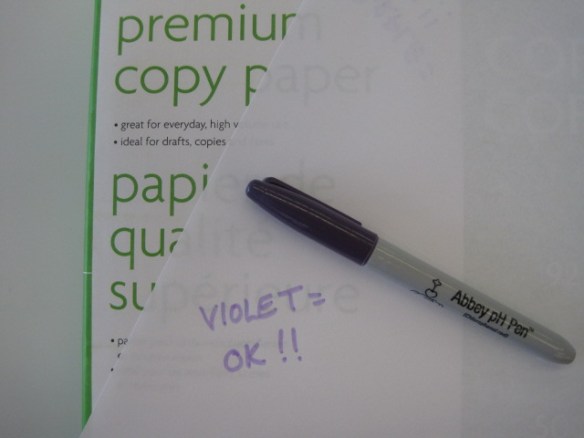 Photographie en couleurs d’un morceau de papier sur lequel il est écrit : « Mauve : bonne nouvelle! ». Il s’agit donc d’un papier sans acide.