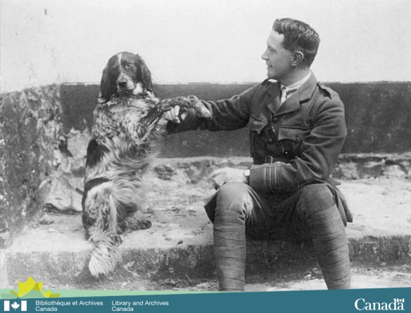 Photographie en noir et blanc montrant un homme en uniforme militaire assis sur des marches avec un chien à ses côtés.