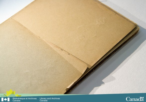 Photographie en couleur montant un carnet de croquis qui a des marques profondément enfoncées sur l’une des pages.