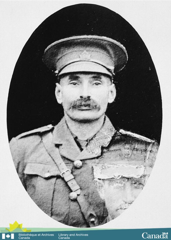 Photographie en noir et blanc d’un homme en uniforme faisant face directement à l’appareil photo 