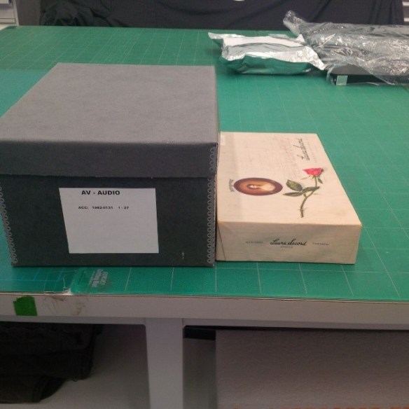 Photo couleur montrant la boîte de chocolat Laura Secord dans laquelle les dictabelts ont été reçus (à droite), et le nouveau contenant dans lequel la collection sera conservée à long terme (à gauche).