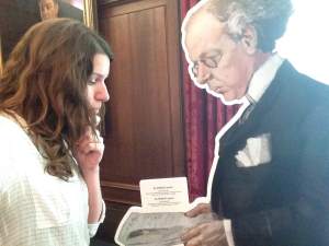 Un égoportrait montrant une femme penchée vers un livre que tient une figure en carton.