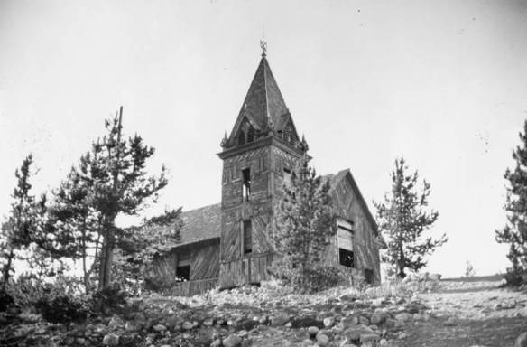 Une photographie en noir et blanc montrant une église en bois abandonnée