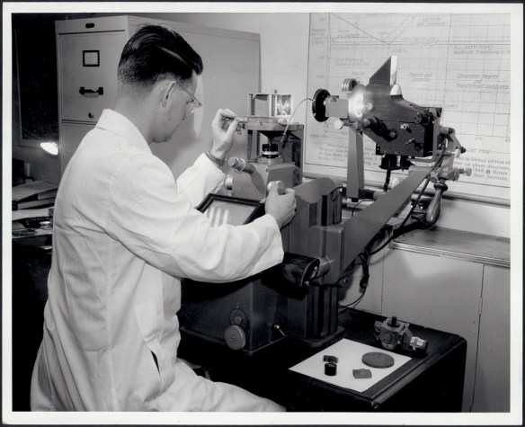 Ingénieur du laboratoire de métallurgie testant la qualité de la structure de l’acier avec un appareil appelé « photomicrographe » vers 1960 (MIKAN 4915724)