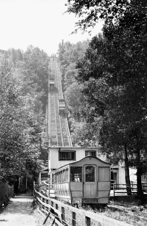 Photographie en noir et blanc d’un funiculaire. Un tram monte la côte alors que l’autre la descend.