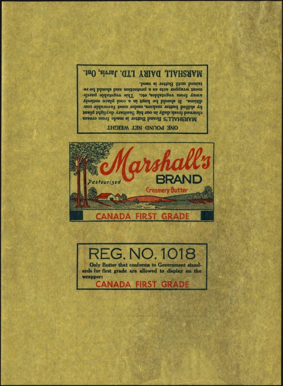 Un emballage de papier ciré polychrome illustrant une ferme avec des arbres. Au-dessus de l’image, on peut lire : « Marshall’s Brand. Creamery Butter. Pasteurized. Canada First Grade » (Marque Marshall. Beurre de crémerie. Pasteurisé. Canada Première Catégorie). Dans un autre encadré (sur la partie du papier qui s’enroule autour du beurre), il est écrit : « Reg. No. 1018. Only butter that conforms to Government standards for first grade are allowed to display on the wrapper CANADA FIRST GRADE » (No d’homologation 1018. On ne peut apposer la mention CANADA PREMIÈRE CATÉGORIE que sur le beurre qui répond aux normes de la première catégorie).