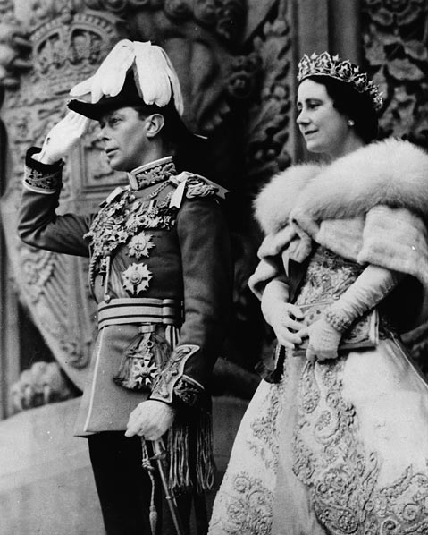 Une photographie noir et blanc du roi George VI saluant la foule à côté de la reine Élisabeth devant les édifices du parlement du Canada. 