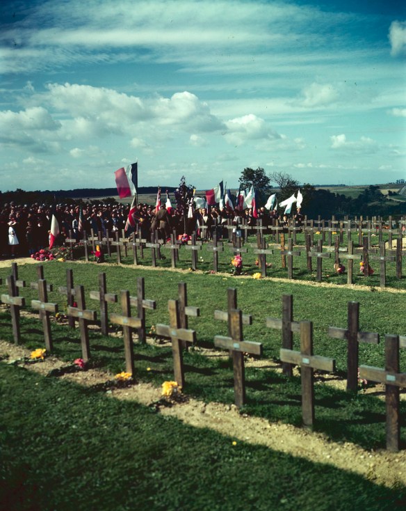 Photo couleur d’un groupe assistant à une cérémonie au cimetière militaire canadien de Dieppe, en France; à l’avant-plan, des rangées de croix temporaires marquent les sépultures.