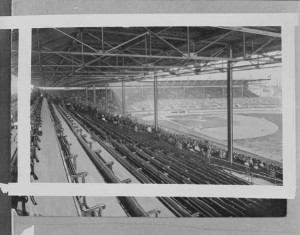 Une photographie noir et blanc d’un stade de baseball, prise de la tribune du champ droit. On aperçoit les gradins et le terrain, incluant le losange et le champ extérieur.