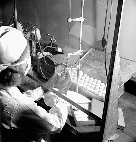 Photo noir et blanc d’une femme remplissant de pénicilline des fioles de 20 cm3 aux laboratoires Connaught.