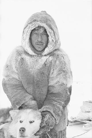 Photo noir et blanc d’un homme avec un chien.