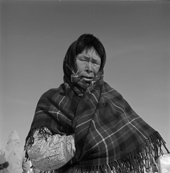 Portrait d’une femme portant un châle en tartan et fumant la pipe.