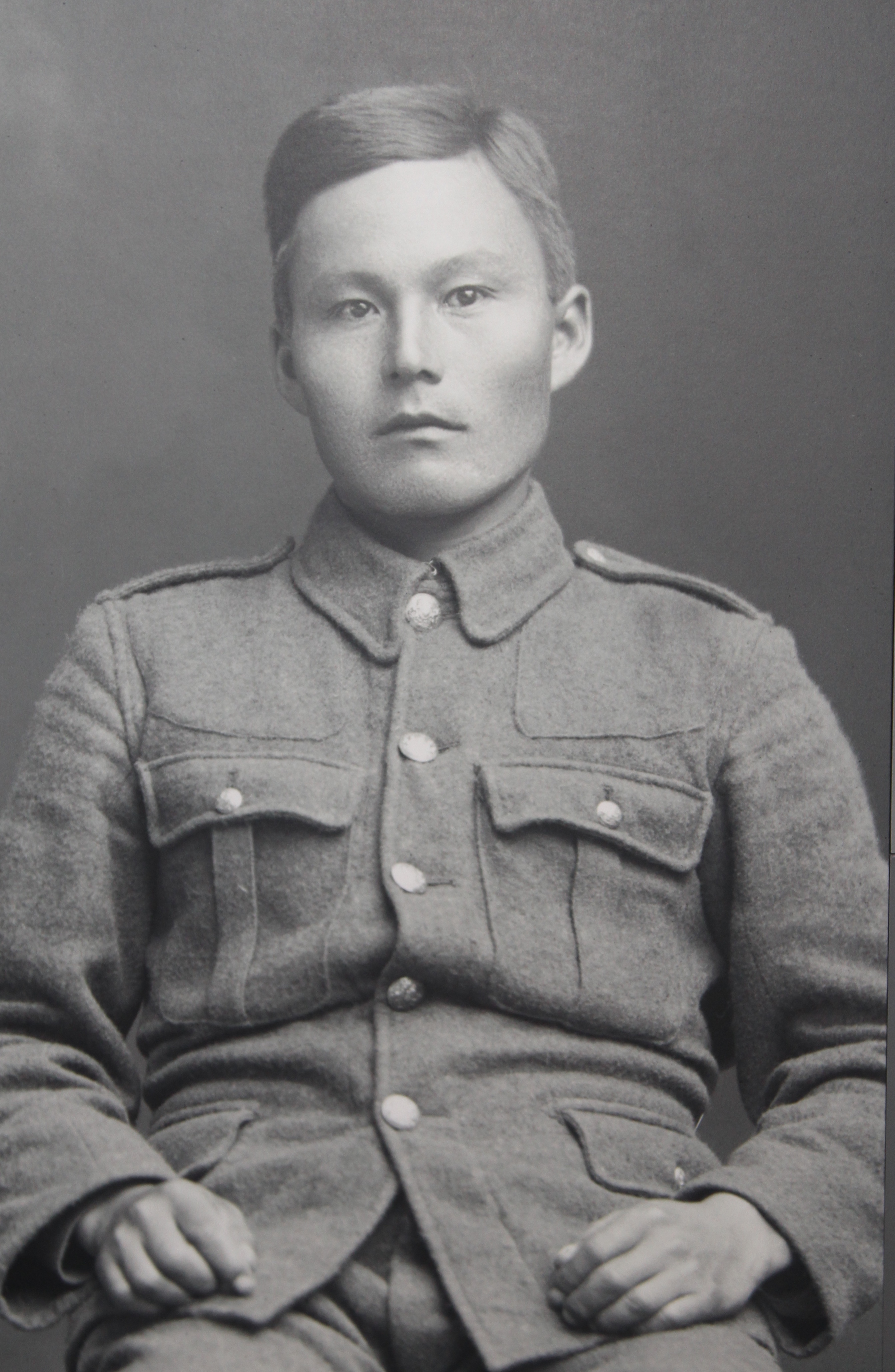 Photo noir et blanc d’un jeune homme inuit vêtu d’un uniforme militaire, qui regarde l’objectif.