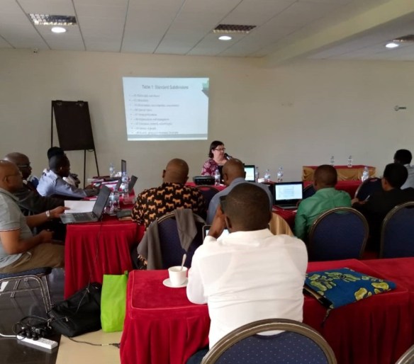 Photo couleur de personnes réunies dans une salle de conférence.