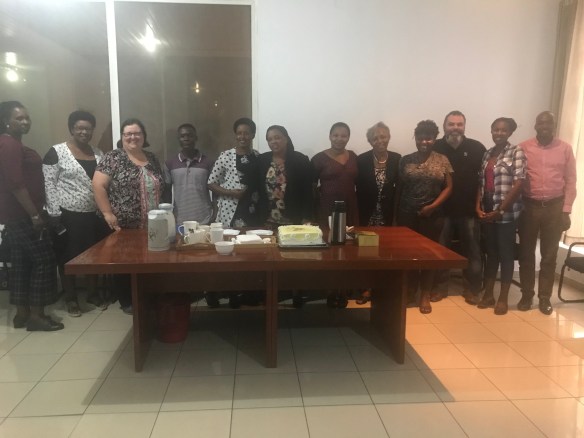 Une photo couleur d’un groupe de personnes réunies autour d’une table.