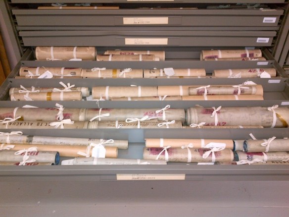 Photo couleur de cartes enroulées, attachées avec un ruban écru.