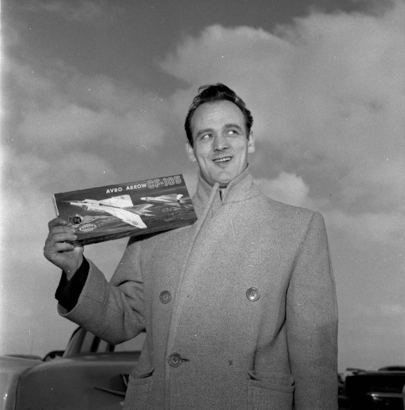 Photo noir et blanc d’un homme tenant la boîte d’une maquette d’avion.