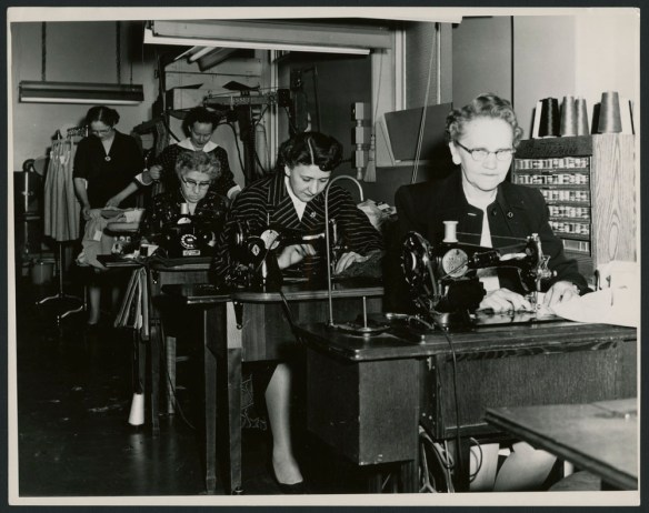 Photo noir et blanc montrant deux repasseuses et trois couturières.