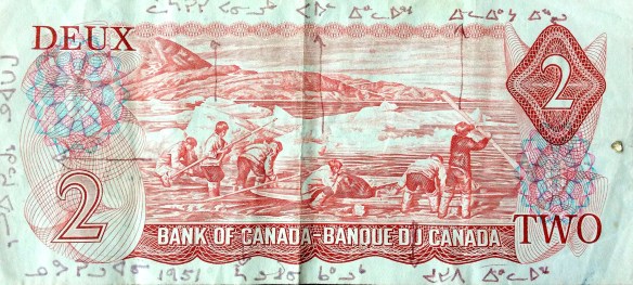 Photo couleur du verso d’un billet de banque canadien de 2 $ de 1975-1979, sur lequel les noms des six personnes qui y figurent sont inscrits en écriture syllabique.