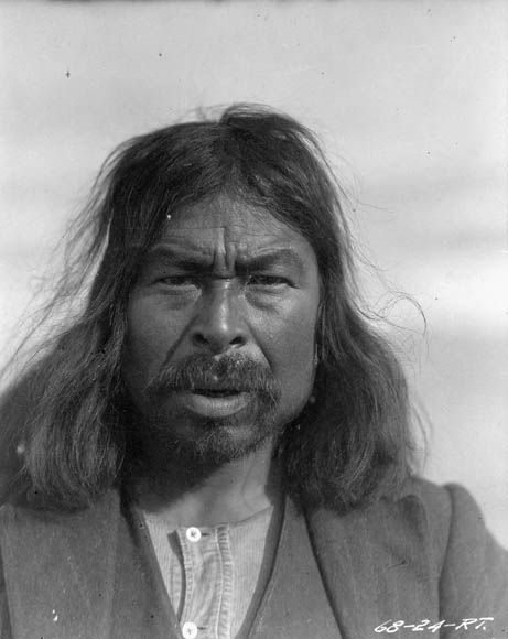 Photo noir et blanc d’un homme aux cheveux longs et portant une moustache.