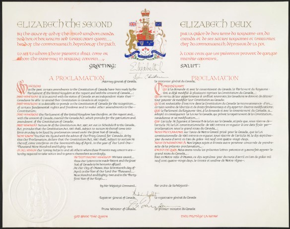 Une page calligraphiée en couleur. On y voit les armoiries du Canada et des signatures, au centre en haut, ainsi que d’autres signatures, au centre en bas. 