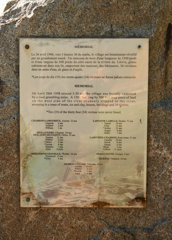 L’inscription sur la plaque se lit comme suit : « Mémorial Le 26 avril 1908, vers 3 heures 30 du matin, le village est brutalement réveillé par un grondement sourd. Un morceau de terre d’une longueur de 1200 pieds et d’une largeur de 500 pieds du côté ouest de la rivière du Lièvre, glisse subitement dans son lit, emportant des maisons, des bâtiments, 34 victimes dans un amas d’eau, de glace et d’argile. Les corps de dix (10) des trente-quatre (34) victimes ne furent jamais retrouvés. »