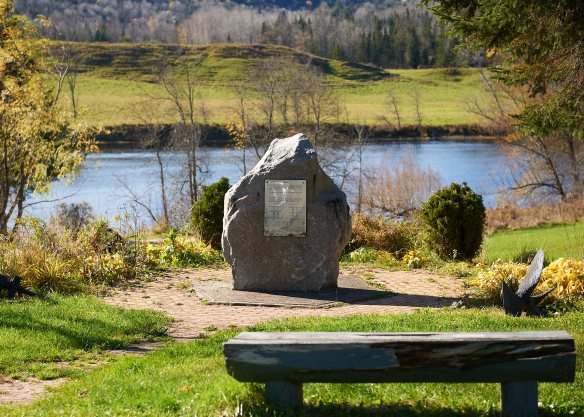 Un grand rocher sur lequel est fixée une plaque métallique relatant l’événement et citant les noms des victimes. Le rocher est situé en face du lieu du glissement. Un banc à proximité surplombe le mémorial et le site du glissement de terrain.
