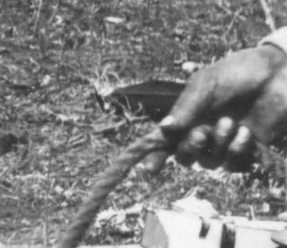 Détail d’une photo noir et blanc montrant la main d’une personne tenant une corde. 