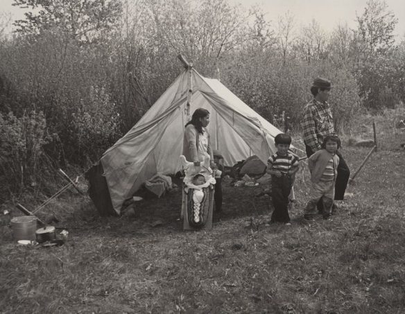 Une famille devant une tente près de Lac Seul, en Ontario.