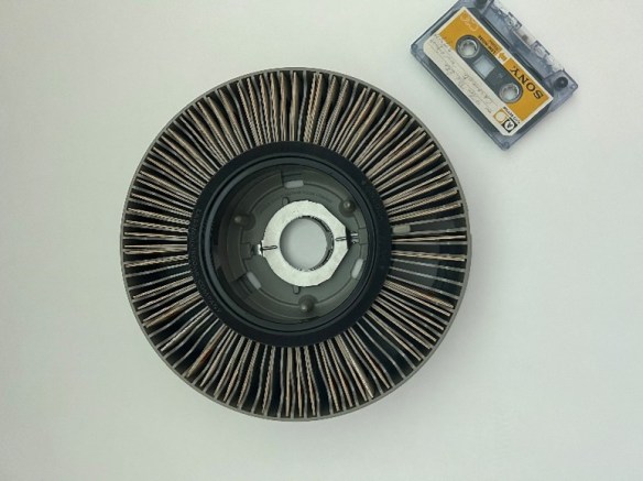 Un carrousel rempli de diapositives avec une cassette sonore à côté, le tout photographié en plongée.