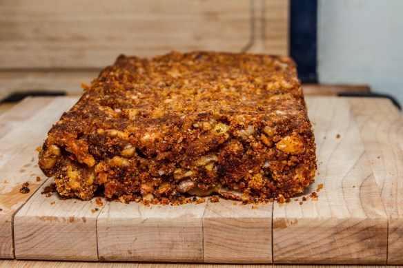 Pain au fromage et aux noix sur une planche de bois.